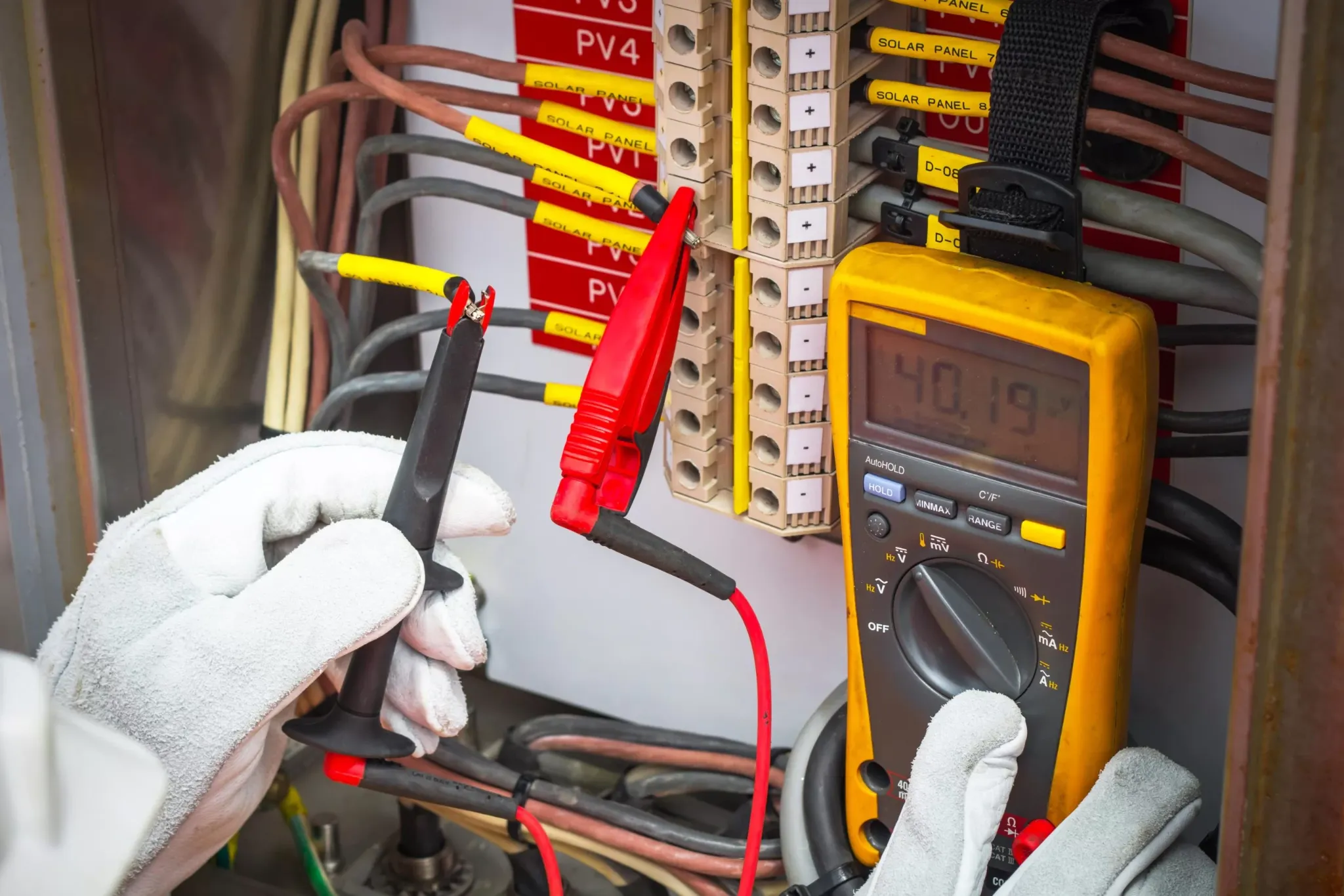 Electrician testing electrical circuits with a meter